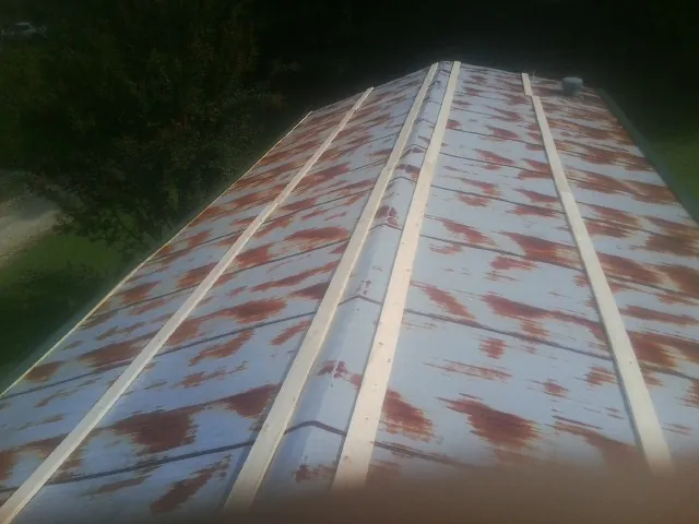 Rusted metal roof panels with new wood purlins before replacement — Storm Damage Roof Repair in West Nottingham by Roofing Brothers