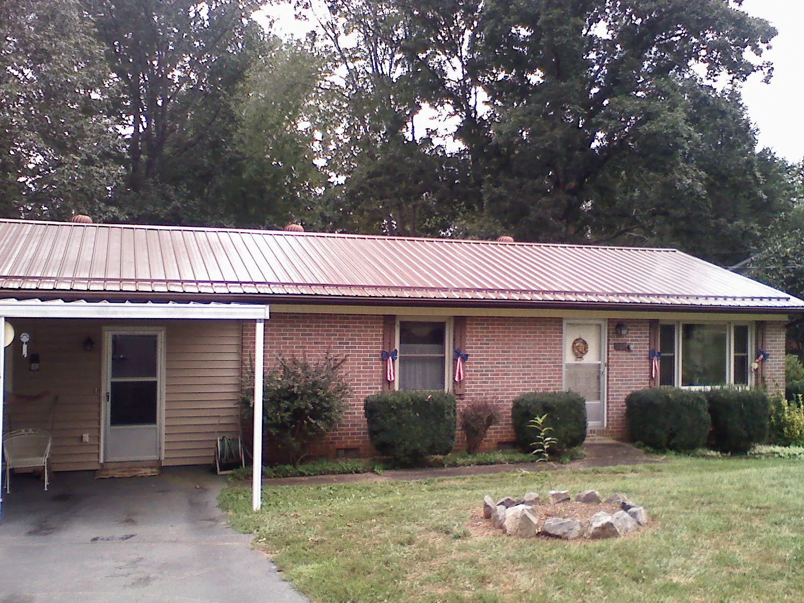 Bronze metal roof and carport on a brick ranch home — Roof Repair work by our crew in West Nottingham